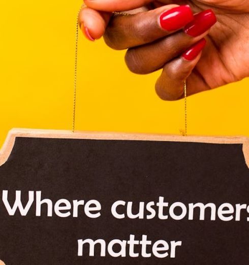 Customer-Centric - Hand holding a sign with 'Where customers matter' on a vibrant yellow backdrop.