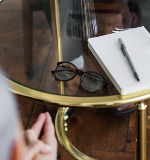 Service Strategy - Two adults discussing mental health in a counseling session across a glass table indoors.