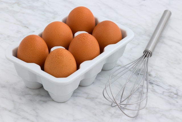 pack-of-organic-eggs-beside-silver-whisk